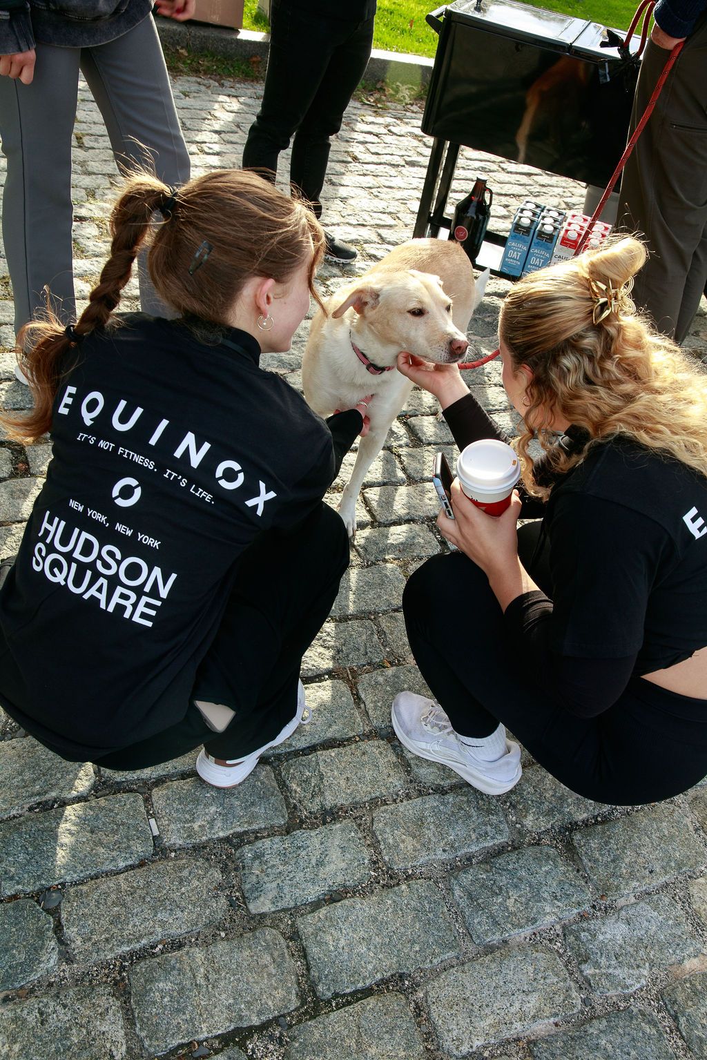Equinox staff greeting a dog beside the coffee cart