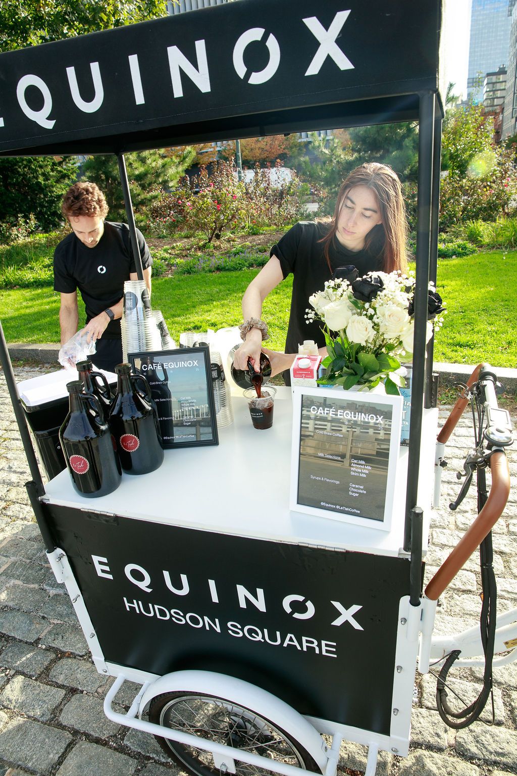 Baristas preparing drinks at a Café Equinox Hudson Square cart