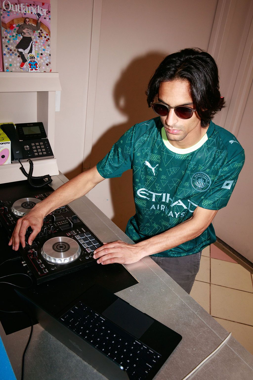 DJ in a green Manchester City jersey mixing music